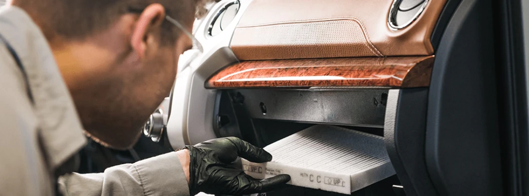 A technician inserting a cabin air filter